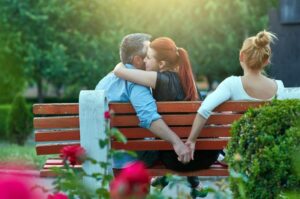 An intimate moment captured as a couple embraces on a park bench